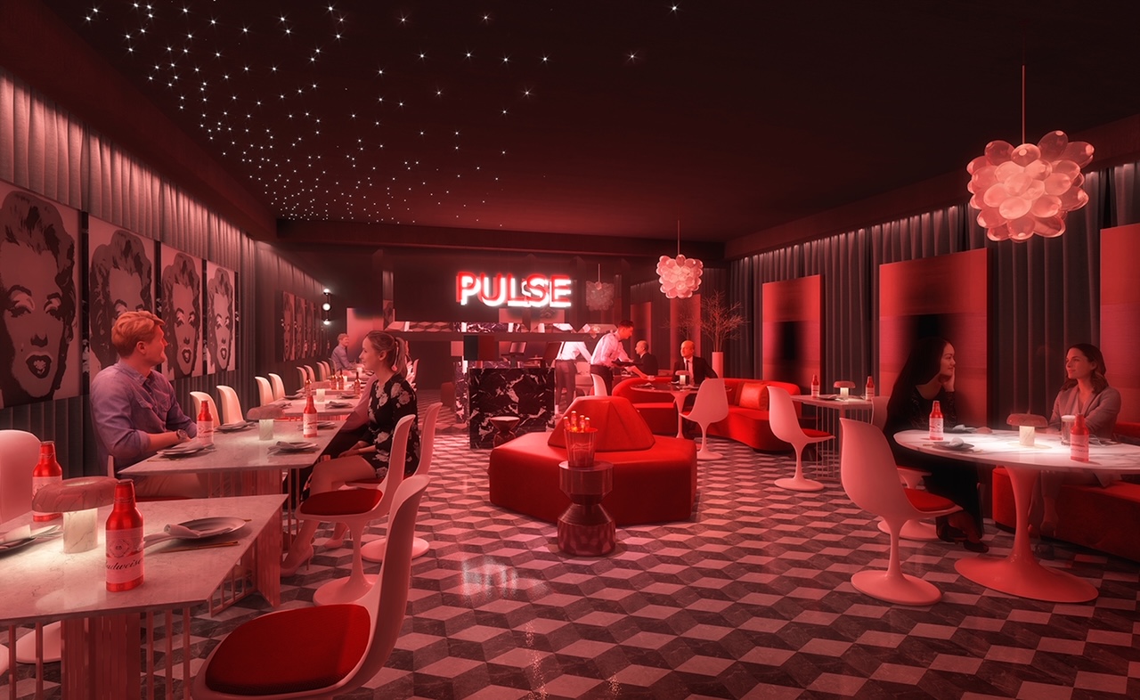 Pulse mezzanine — red banquette under faceted lit ceiling, view to lower level